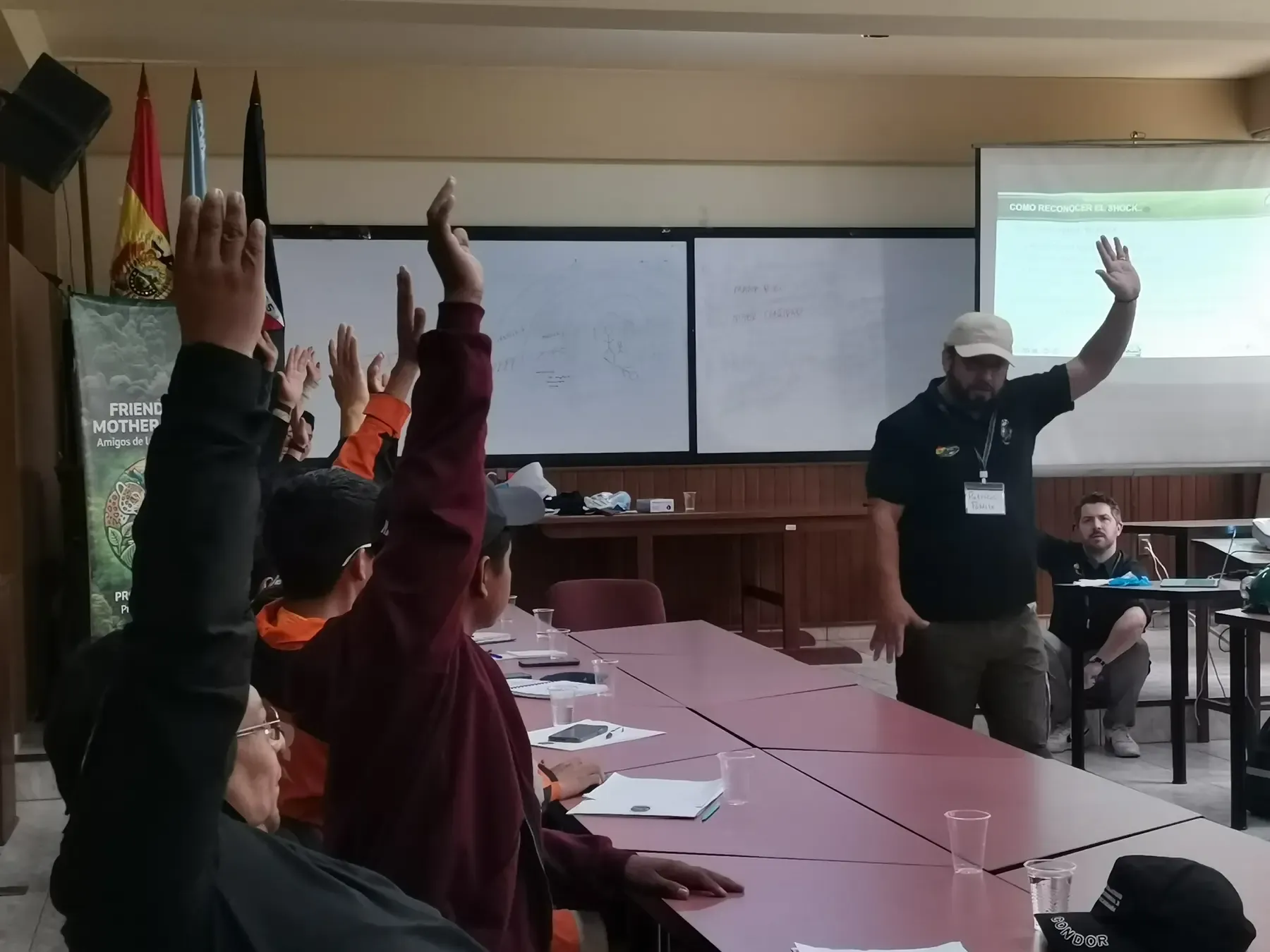 Participantes levantan la mano respondiendo al instructor durante la clase sobre reconocer el shock